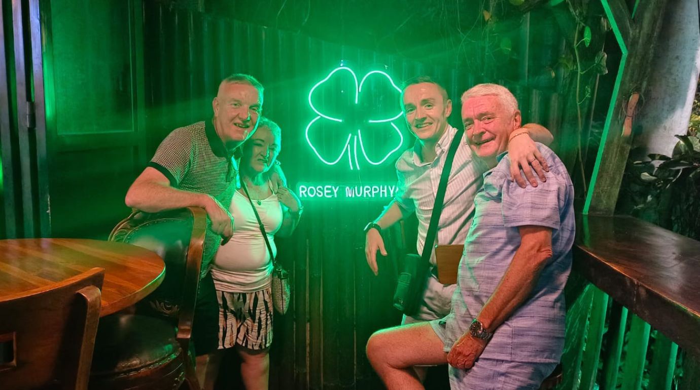 Guests by the Rosey Murphy's Irish Pub signboard
