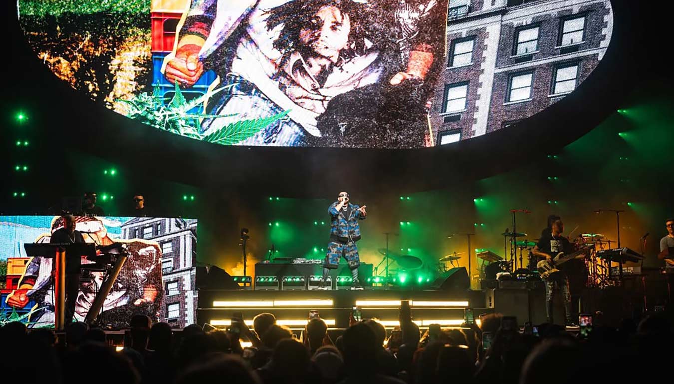 Sean Paul performing against the backdrop of a huge screen