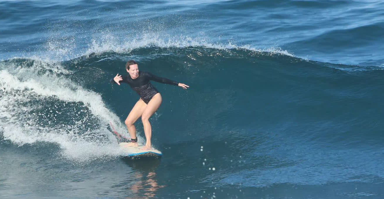 Woman is learning to surf at Dawn Patrol Bali Surf School