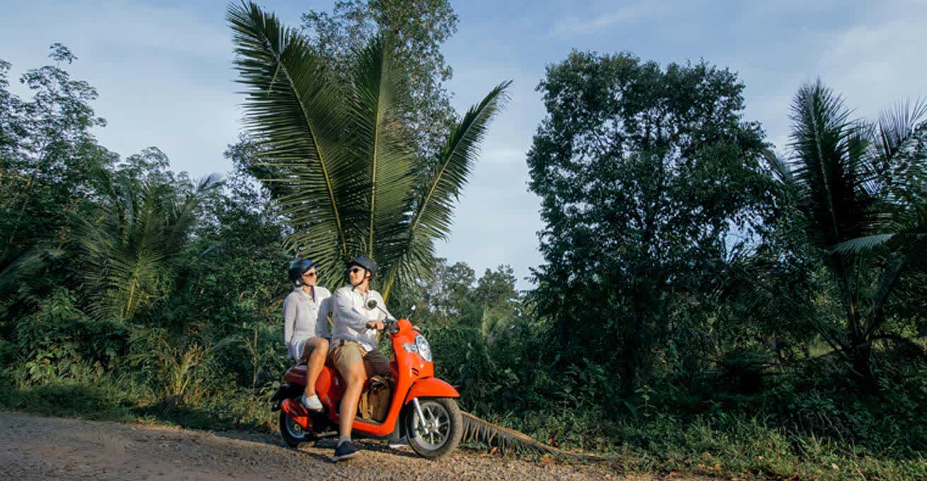 The couple is driving the rental scooter in Bali
