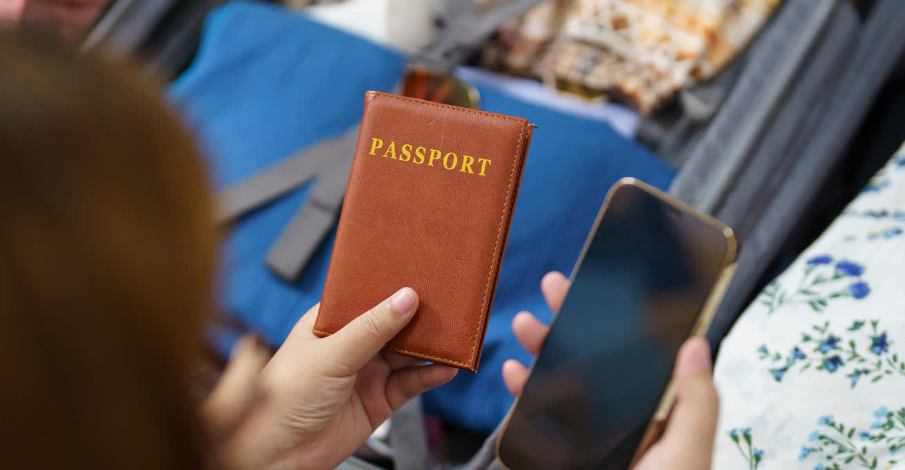 Woman is holding the passport and phone in her hands