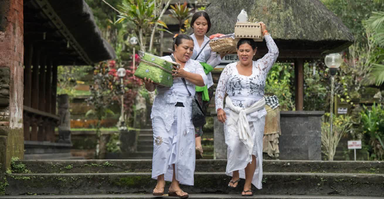 Indonesian women in traditional clothes is carrying the baskets