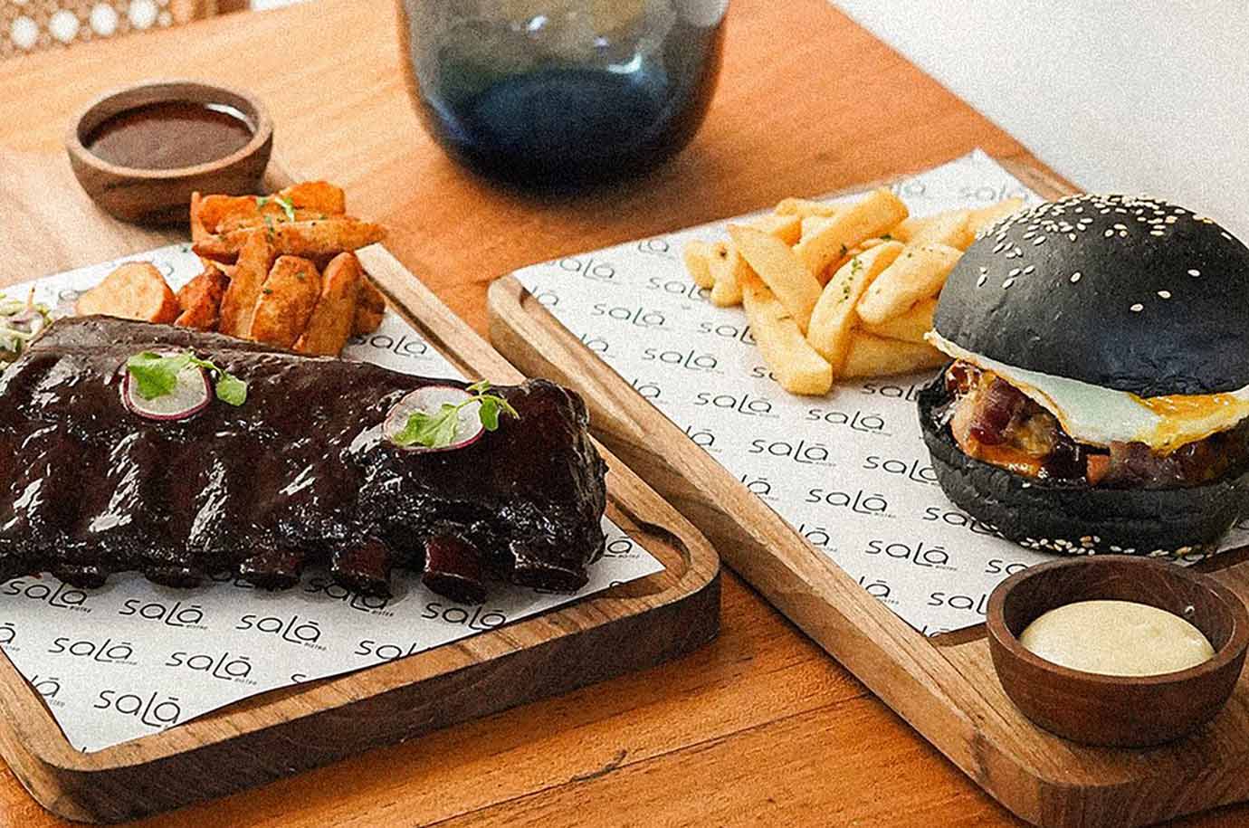 Black burger, french fries and meat from Sala Bistro