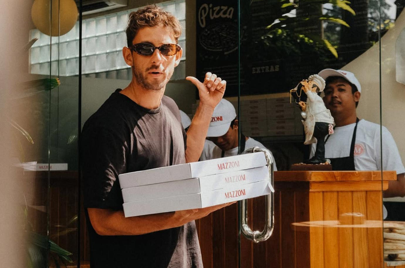 Guest with pizza to go in the Mazzoni Pizza