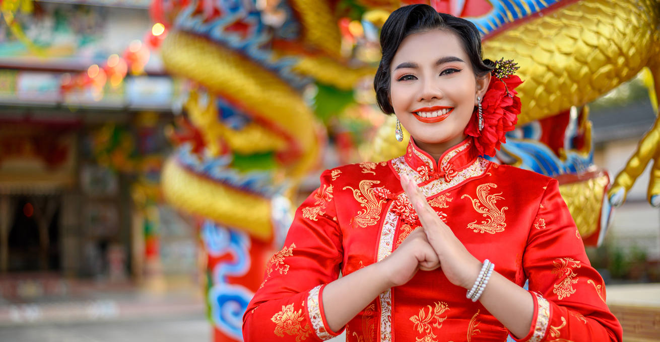 A girl in national dress gestures to congratulate the Chinese New Year