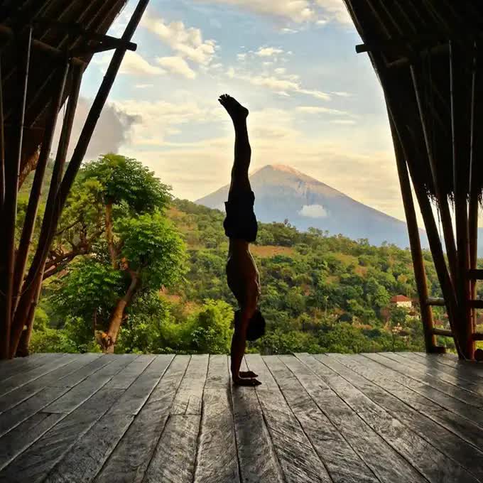 A man doing yoga on with volcano view
