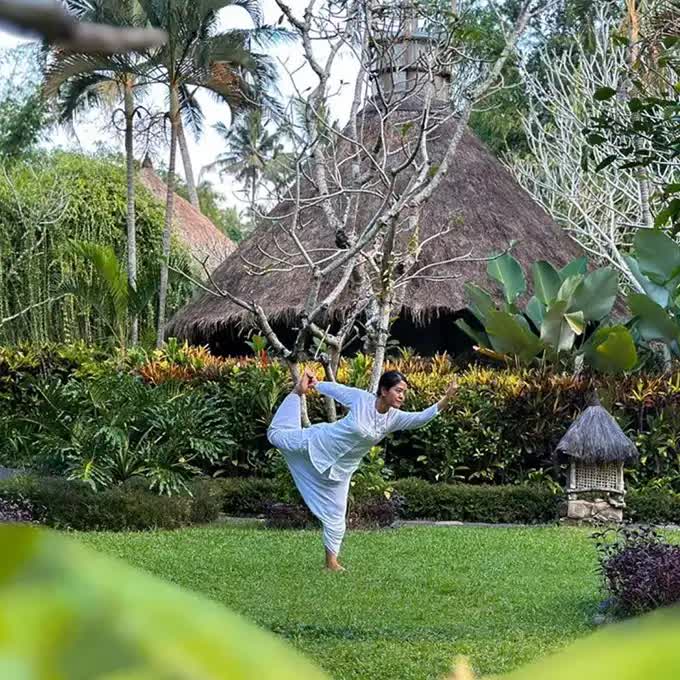 Woman doing yoga lessons fully surrounded with nature