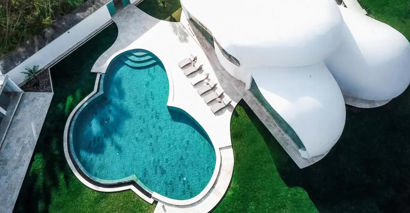 Aerial view of the round white building of the Boutique Hotel Sensation with a swimming pool
