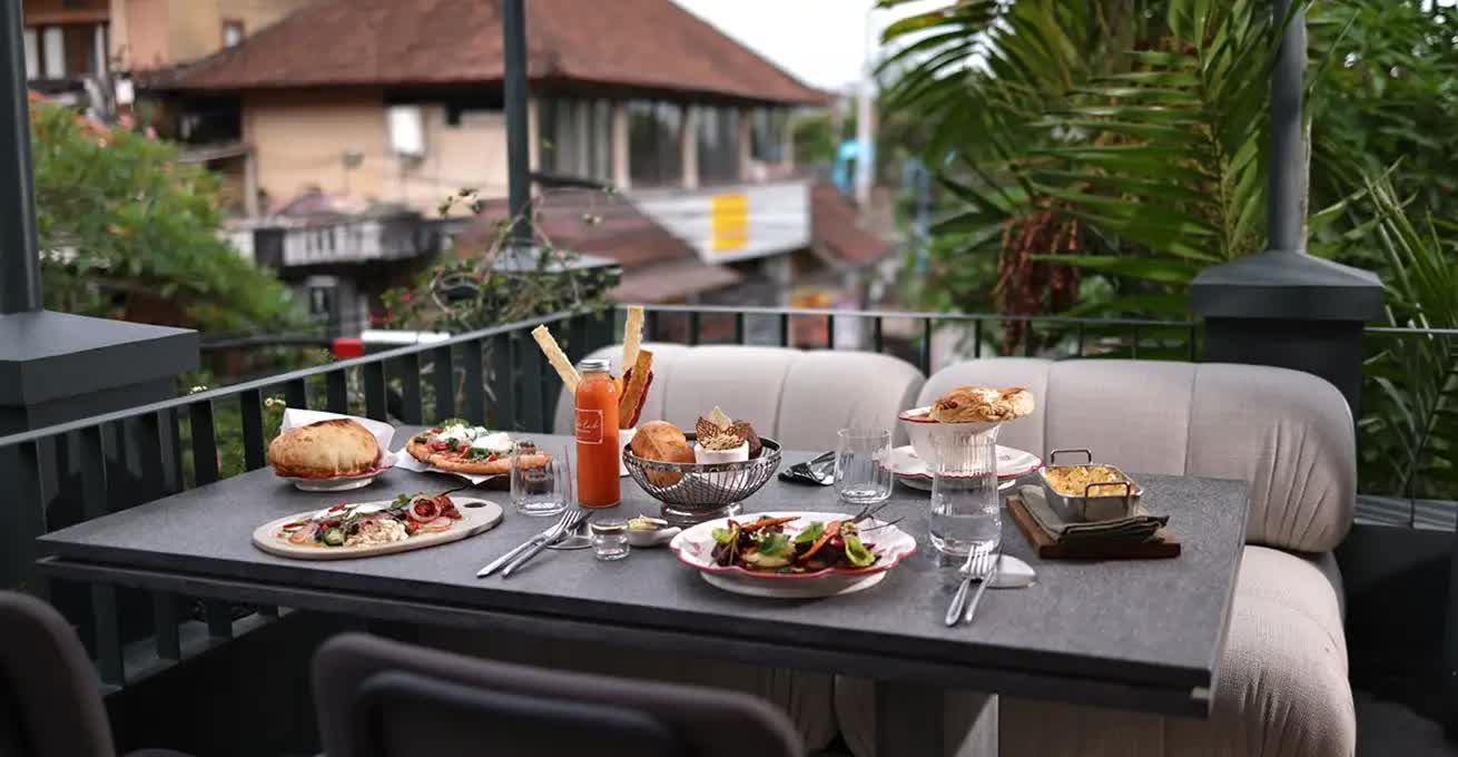 Table served with various dishes on the terrace of Brie Restaurant & Cheesery Bali