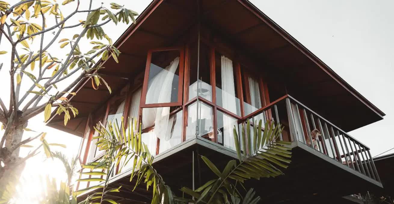 Bottom view of a hotel Grün Canggu Garden treehouse apartment with a balcony and a dog on it