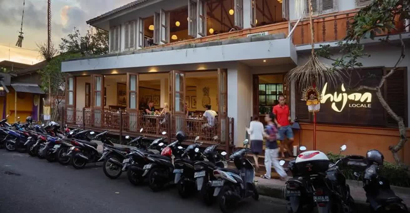 Hujan Locale restaurant building and parking area with scooters