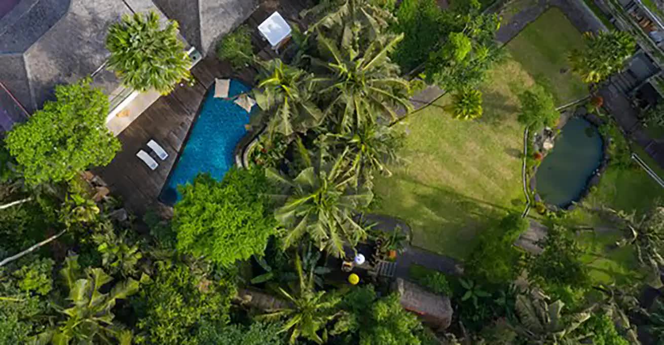 Aerial view of the courtyard with the swimming pool and green landscape near the spa salon Plataran Ubud