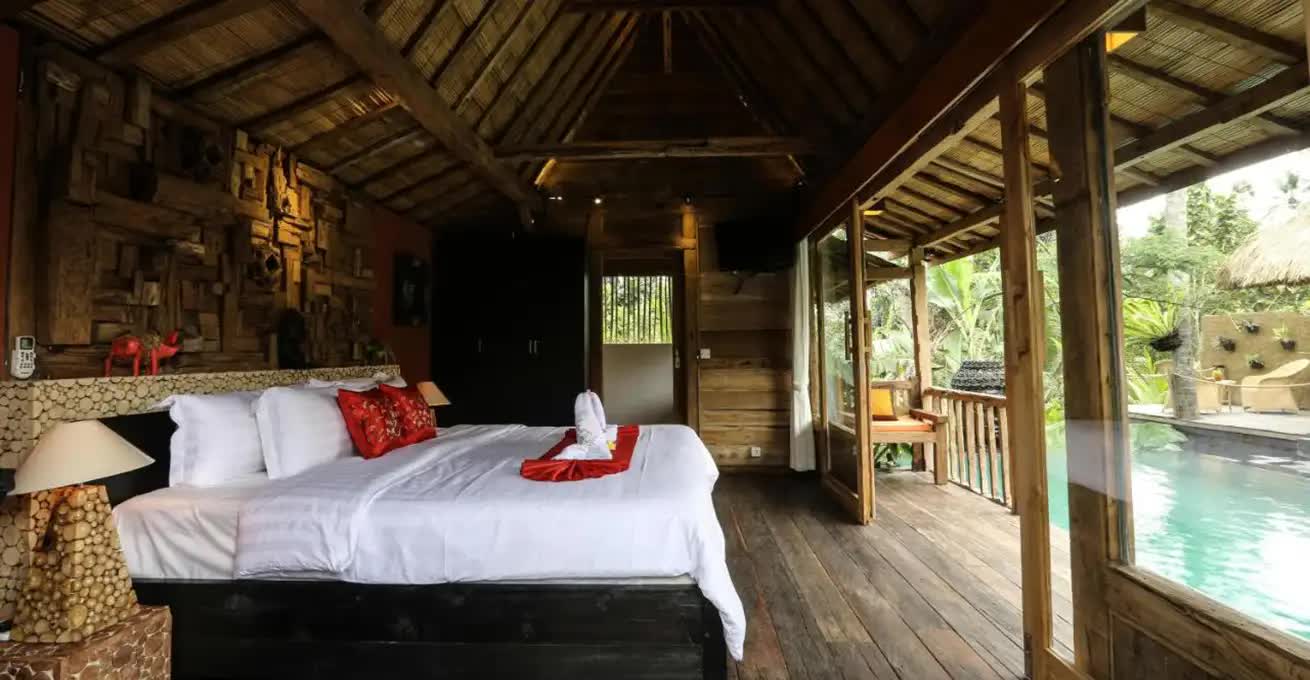 Typical Balinese bedroom interior in Ubud Virgin Villa with access to the pool