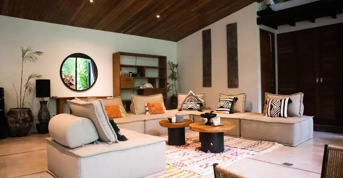 Living room with the huge sofa and wooden furniture in Ubud Zen River House