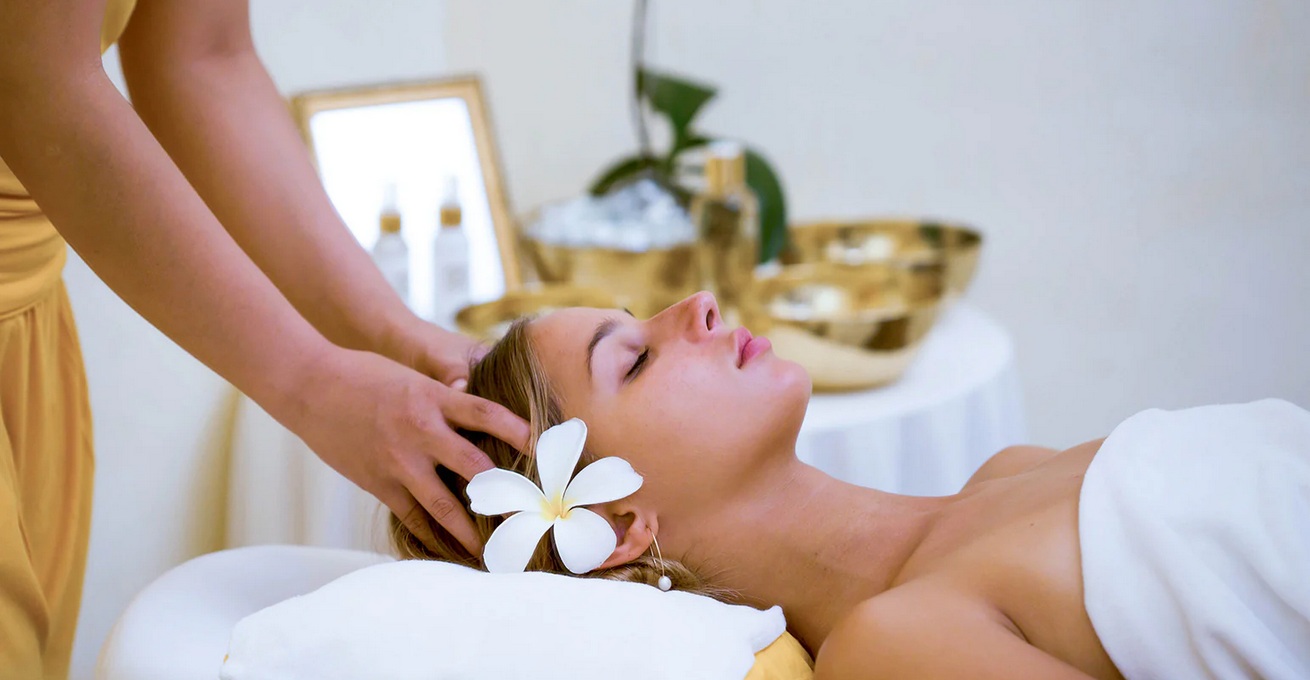Woman with flower behind ear enjoying massage