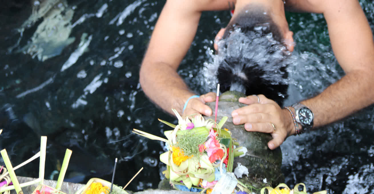 A man pours water on himself during the Purification Ceremony